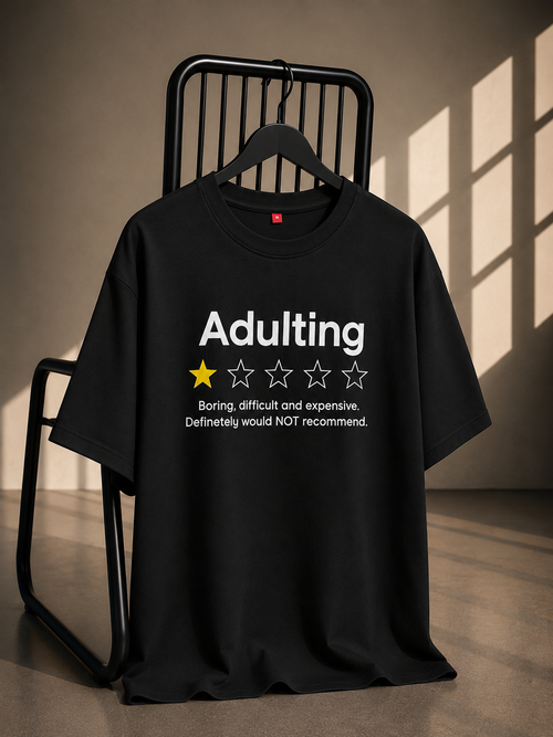 Black oversized French Terry cotton T-shirt featuring a funny Adulting one-star rating graphic on the front.