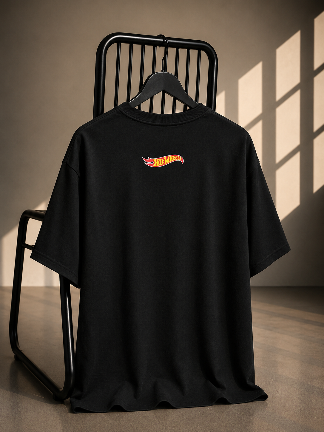 Black oversized French Terry cotton T-shirt featuring a minimalist Hot Wheels logo on the back.