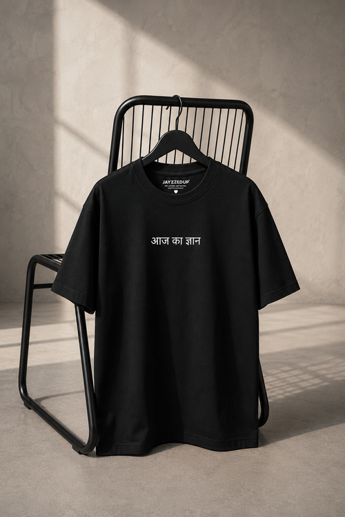 Black oversized unisex graphic T-shirt featuring a minimal "Aaj Ka Gyaan" Hindi chest print, made from 220–240 GSM bio-washed French Terry cotton.
