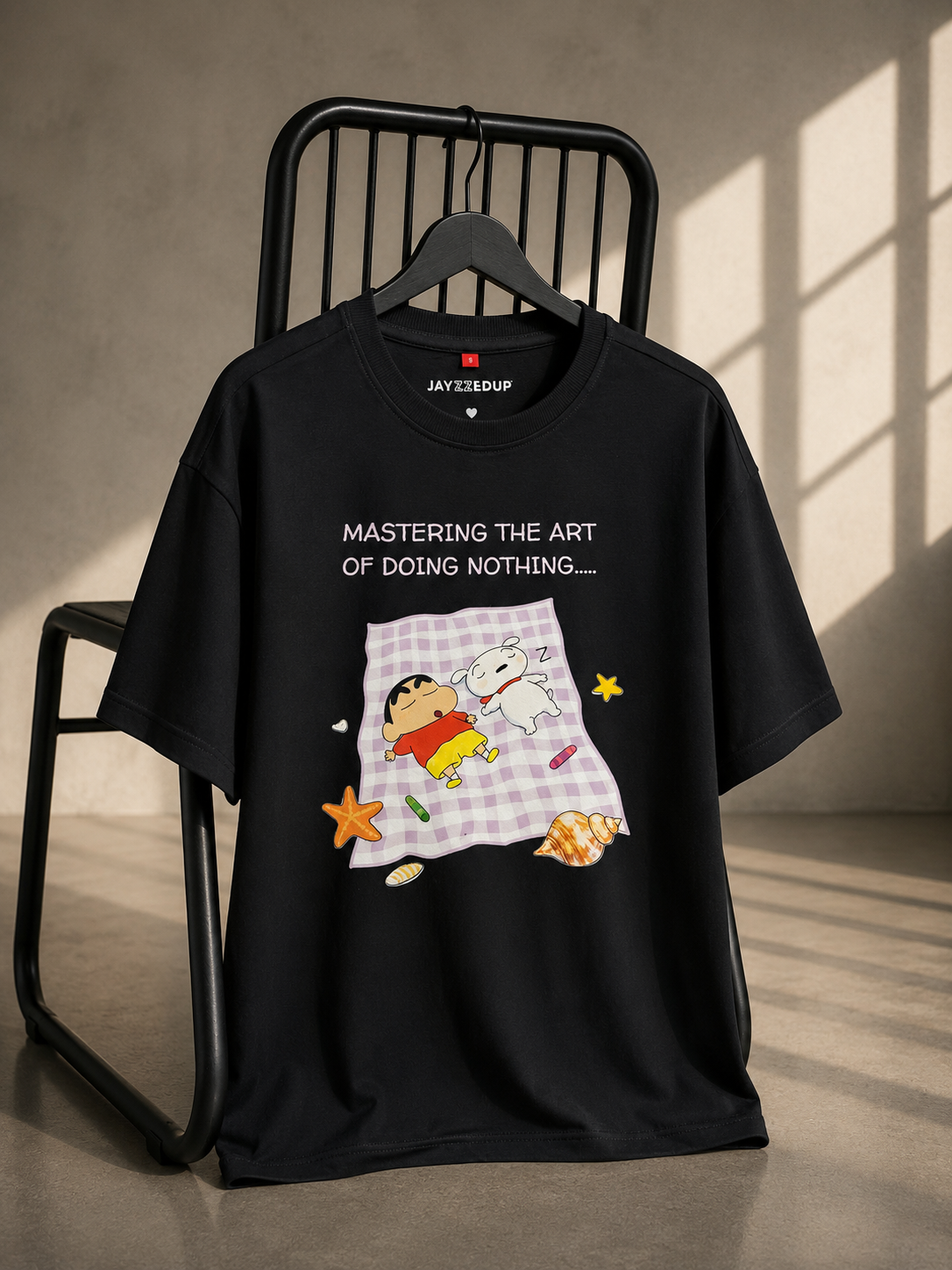 Black oversized unisex graphic T-shirt featuring a playful "Mastering the Art of Doing Nothing" illustration, made from 220–240 GSM bio-washed French Terry cotton.