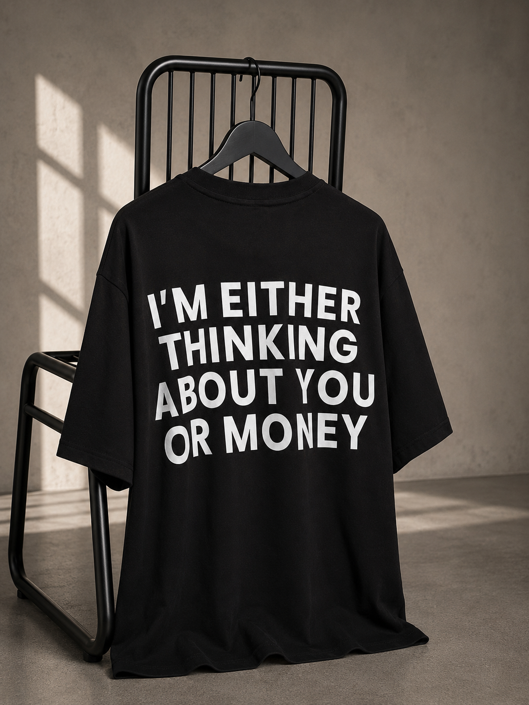 Black oversized unisex graphic T-shirt with a bold white typography statement printed on the back.