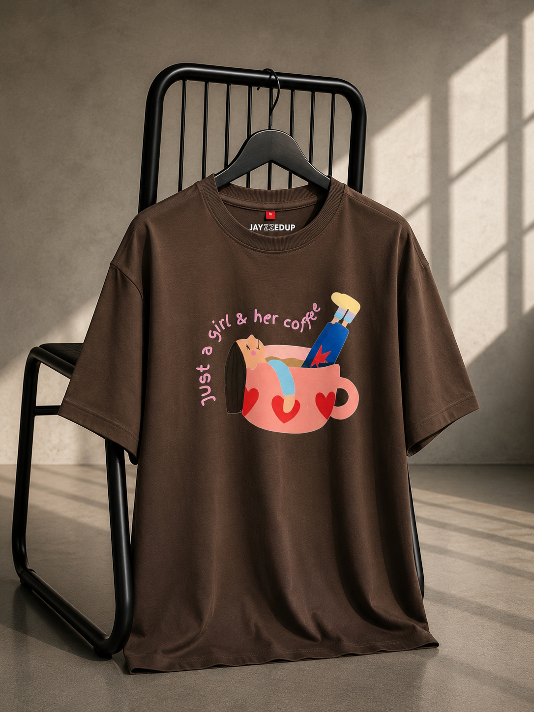 Brown oversized unisex graphic T-shirt featuring a playful "Just a Girl & Her Coffee" coffee mug illustration, made from 220–240 GSM bio-washed French Terry cotton.