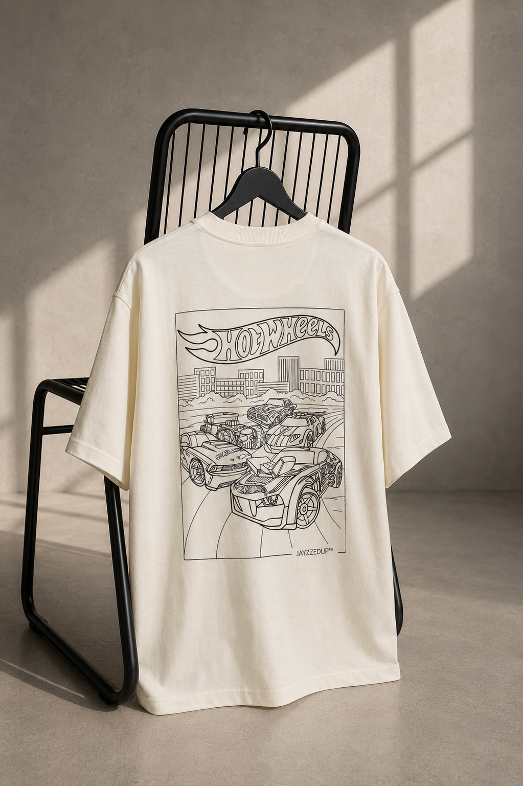 Off-white oversized unisex T-shirt featuring a detailed Hot Wheels line art illustration of performance cars on heavyweight French Terry cotton.