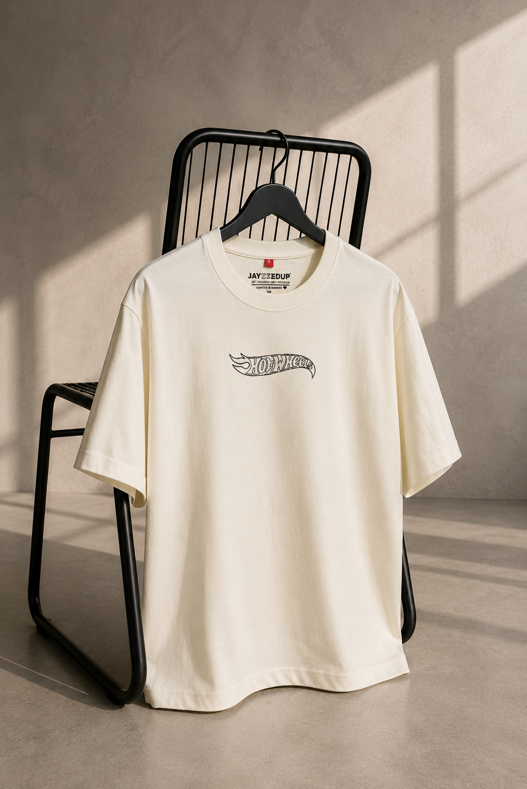 Off-white oversized unisex graphic T-shirt featuring a minimalist Hot Wheels chest logo, made from 220–240 GSM bio-washed French Terry cotton.
