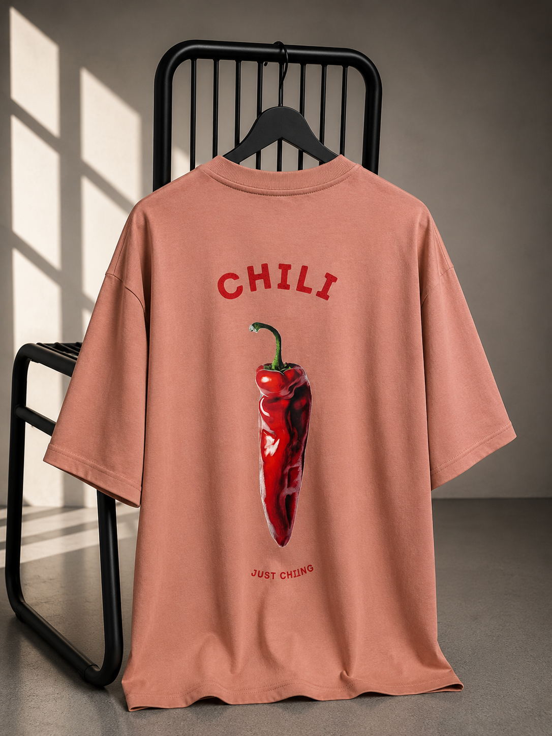 Pink oversized unisex graphic T-shirt featuring a playful chili illustration and back print, made from heavyweight French Terry cotton.
