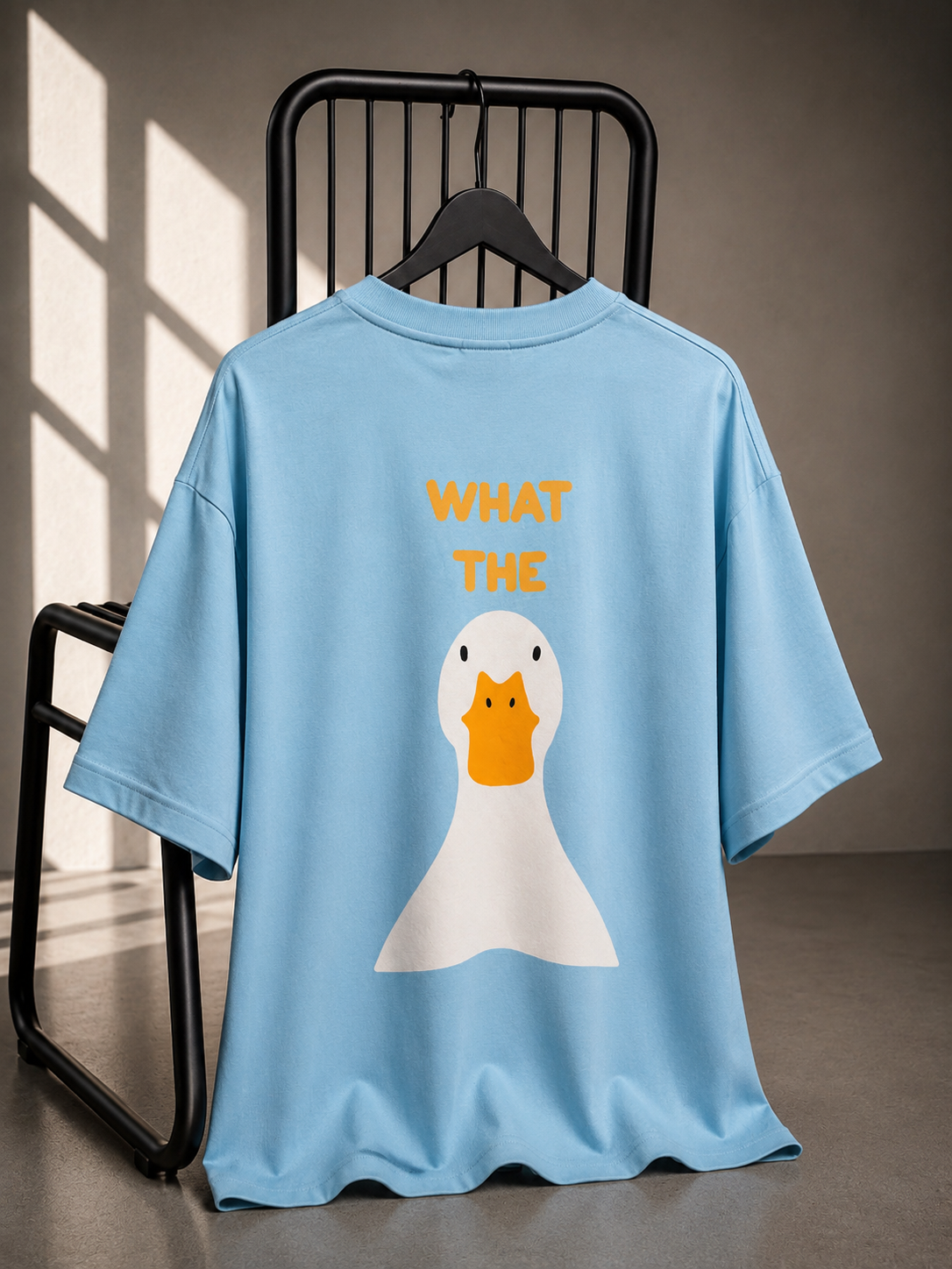 Sky blue oversized unisex graphic T-shirt featuring a playful duck illustration and bold back print, made from heavyweight French Terry cotton.
