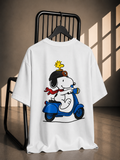 White oversized graphic T-shirt featuring Snoopy riding a blue scooter with Woodstock on the back.