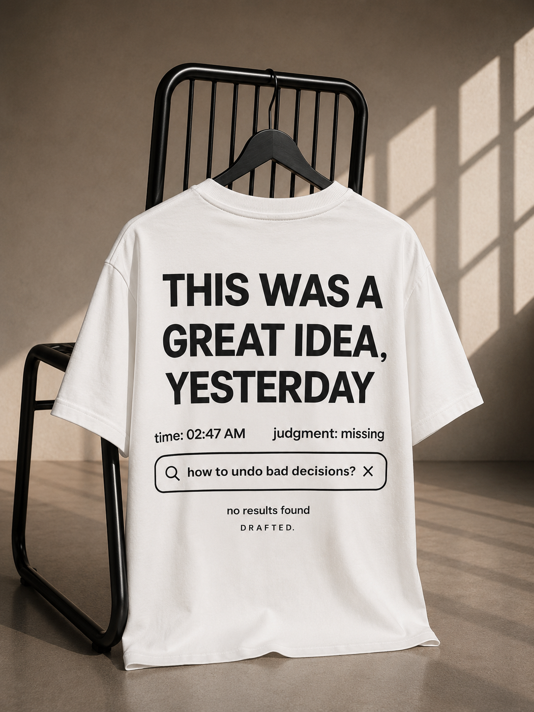 White oversized unisex T-shirt featuring a bold typography back print reading "THIS WAS A GREAT IDEA, YESTERDAY" with a humorous search bar graphic on heavyweight French Terry cotton.