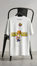 White oversized unisex gaming-inspired graphic T-shirt with playful retro game artwork on the back.
